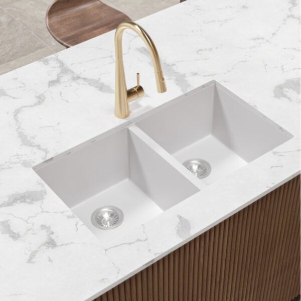 Forio 813 matt white double bowl quartz sink undermounted in a marble benchtop with a brass pull-out mixer