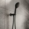 Coen 3 function shower on bracket in black installed on a tiled shower wall