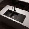Forio 1160 quartz double bowl sink with drainer in matt black, installed in a white stone kitchen benchtop